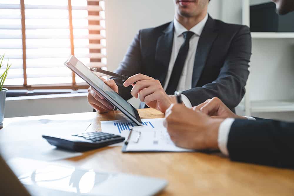 A Man In A Suit Holding A Tablet